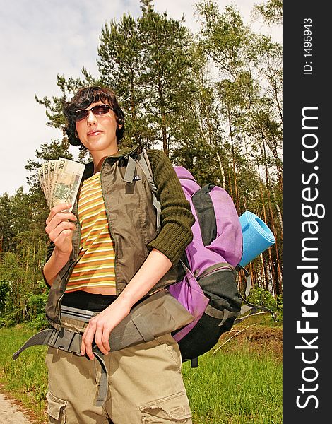 Girl, young woman with a backpack and money for the trip-in a forest