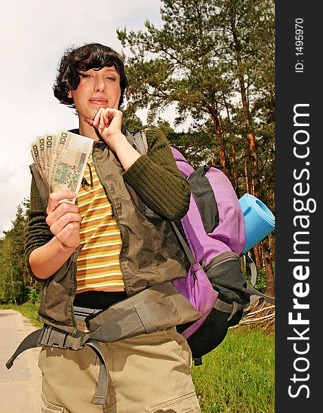 Girl, young woman with a backpack and money for the trip-in a  forest