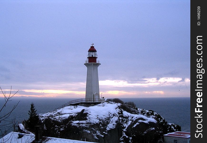 Lighthouse in winter at sunset time