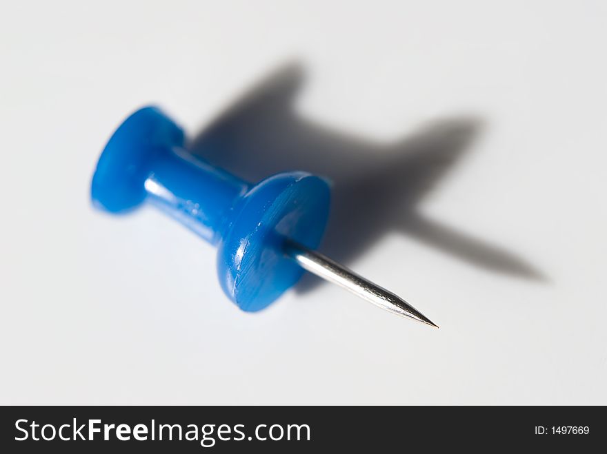 Plastic pin on grey background with long shadow. Plastic pin on grey background with long shadow