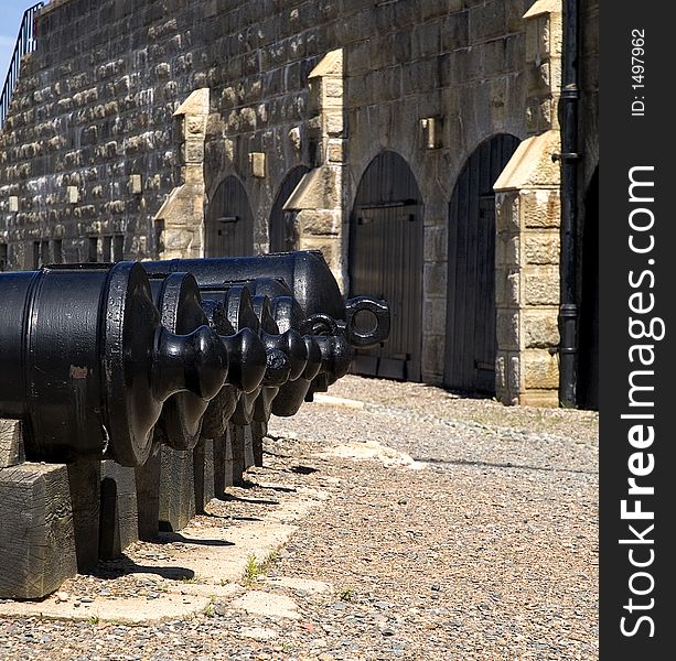 A row of old cannons in a historic fort. A row of old cannons in a historic fort
