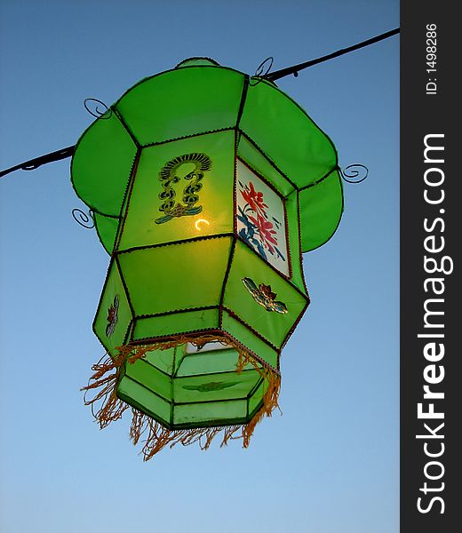 Shot of a beautiful green lantern taken against the blue sky during the lights festival. Shot of a beautiful green lantern taken against the blue sky during the lights festival.