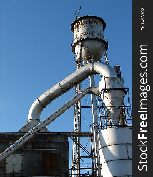 Factory building with water tower and metal pipes