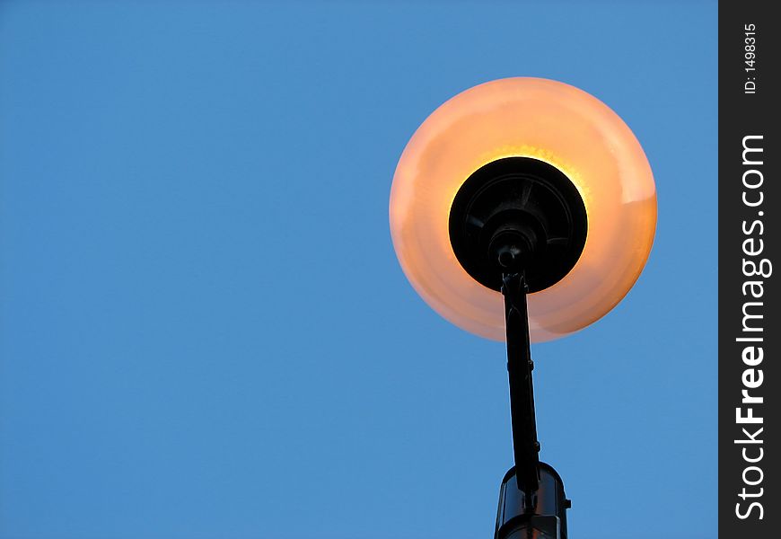 Street light against the clear blue sky, view from below. Space for text. Street light against the clear blue sky, view from below. Space for text.