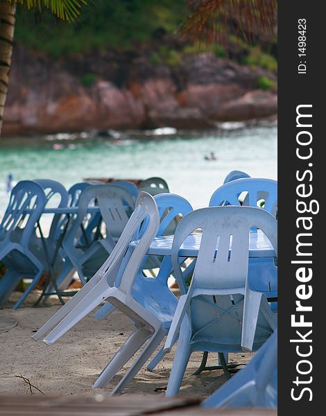 Tables & chairs by the beach provided by a beach restaurant for dining