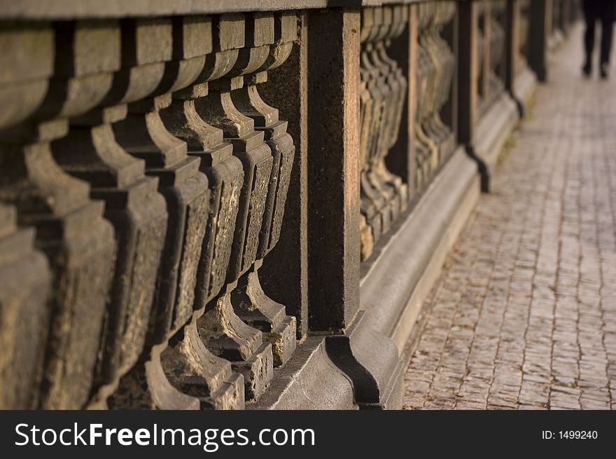 Pillars and man walking away, taken on bridge in prague.