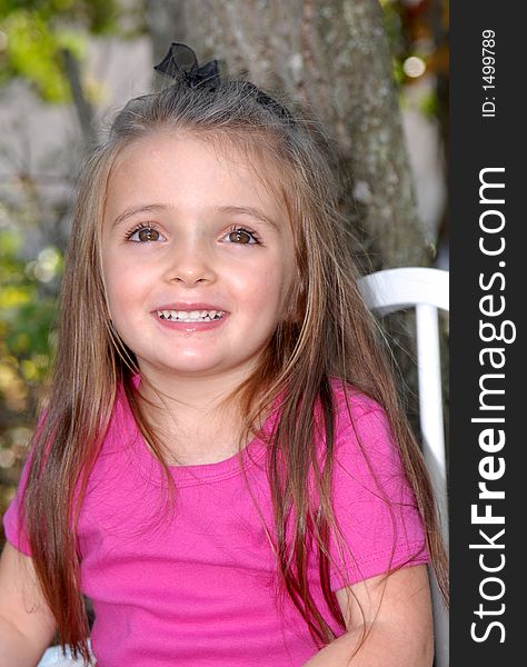 A pretty little brown haired, brown eyed girl smiling for her photos.  

She's in an outdoor setting and is wearing a hot pink shirt. A pretty little brown haired, brown eyed girl smiling for her photos.  

She's in an outdoor setting and is wearing a hot pink shirt.