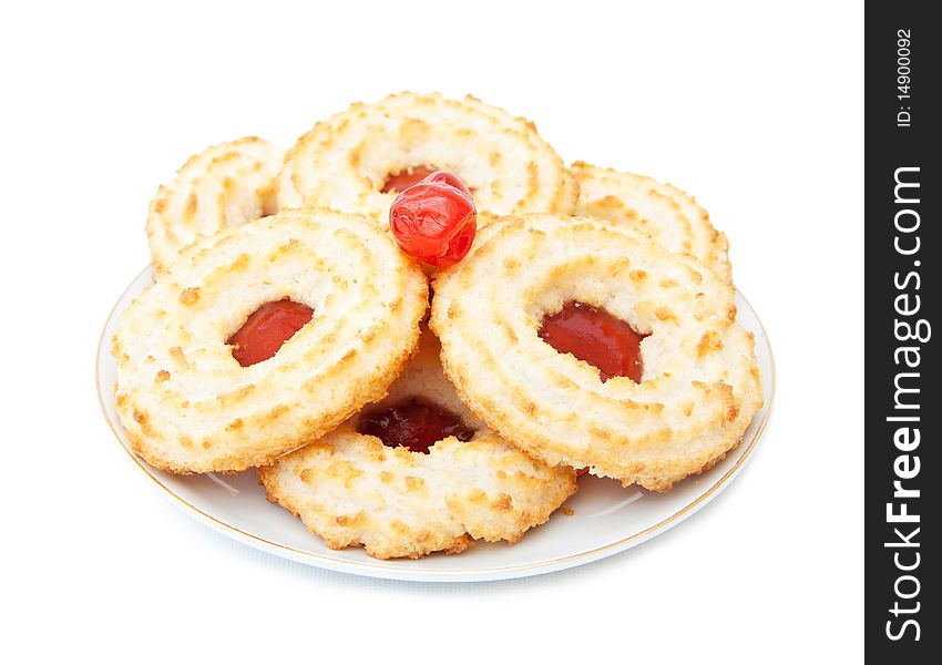 Delicious treats - a plate with jam and coconut biscuits. Cherry on top. Isolated over white background.