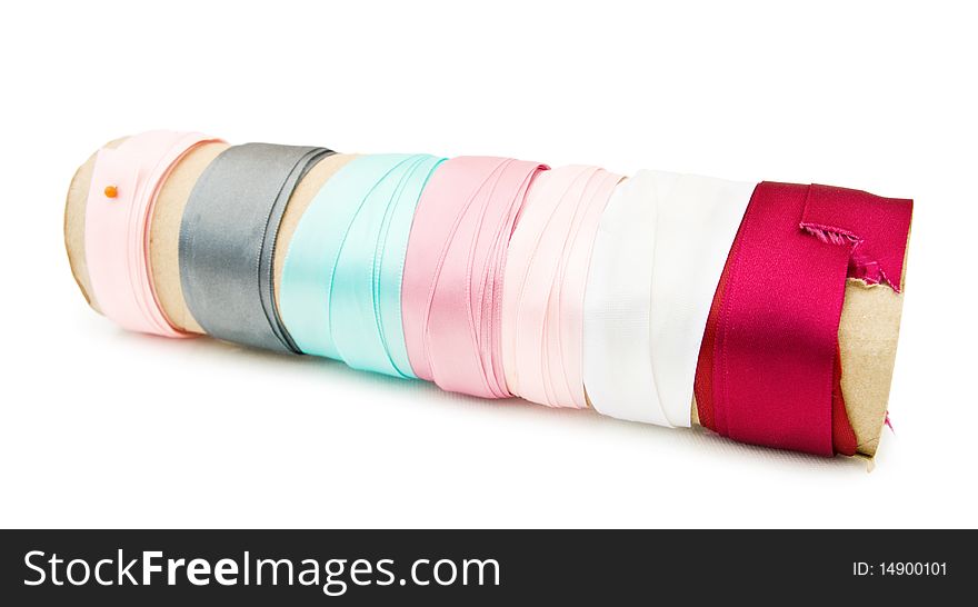 Colorful satin ribbons on a roll - for dressmaking and crafts. Isolated over white background. This image is exclusive to Dreamstime.
