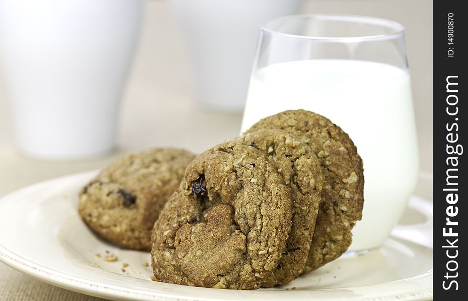 Fresh oatmeal raisin cookies and a glass of milk. Fresh oatmeal raisin cookies and a glass of milk