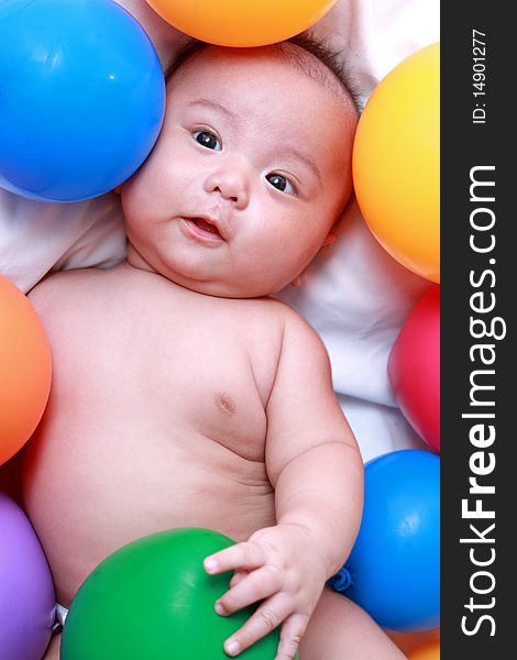Asian infant sorrounded with colored balloons. Asian infant sorrounded with colored balloons
