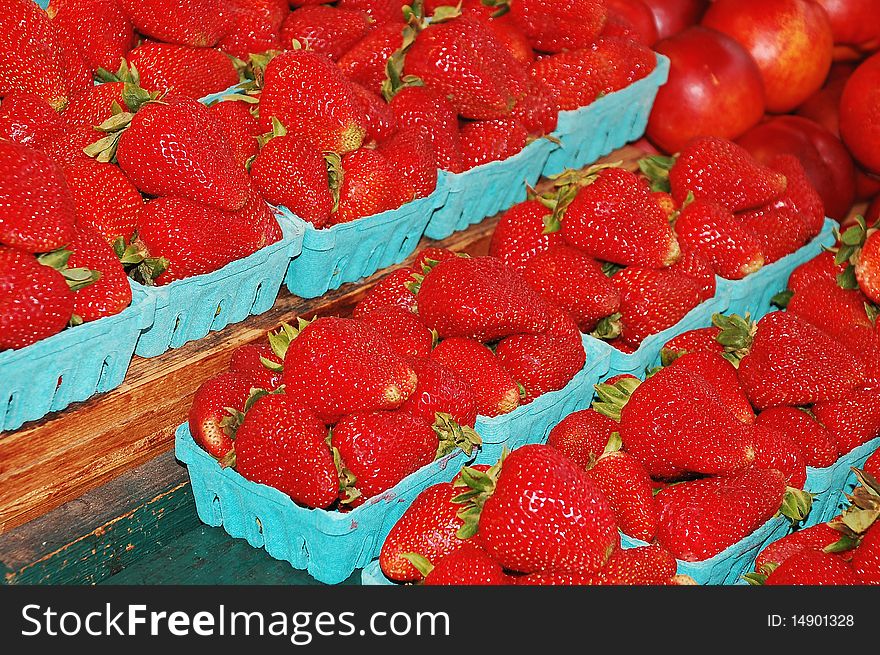 Freshly picked strawberries in baskets at the market. Freshly picked strawberries in baskets at the market