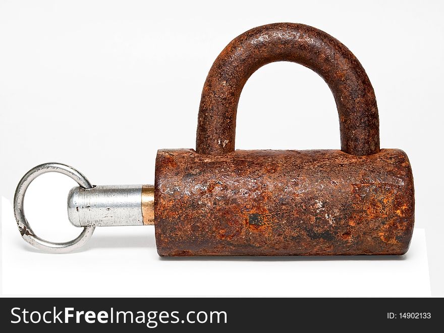 The lock together with a key on a white background is shown is isolated. The lock together with a key on a white background is shown is isolated