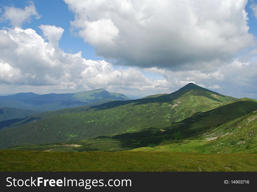 Summer mountain tops in a landscape under clouds