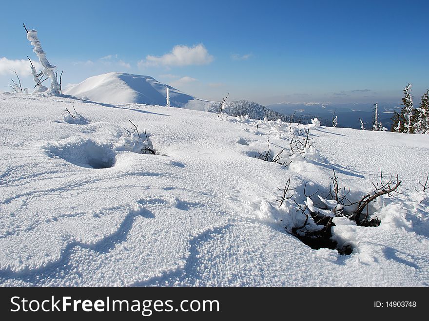 White mountain with the dark blue sky in a winter landscape with a snow hillside. White mountain with the dark blue sky in a winter landscape with a snow hillside.