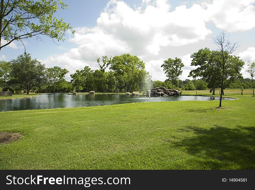 Peaceful country landscape with grass, trees and a large pond. Peaceful country landscape with grass, trees and a large pond