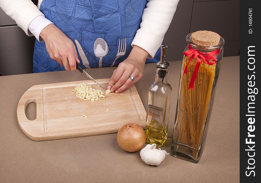 Woman cutting up some garlic with oil and onion. Woman cutting up some garlic with oil and onion