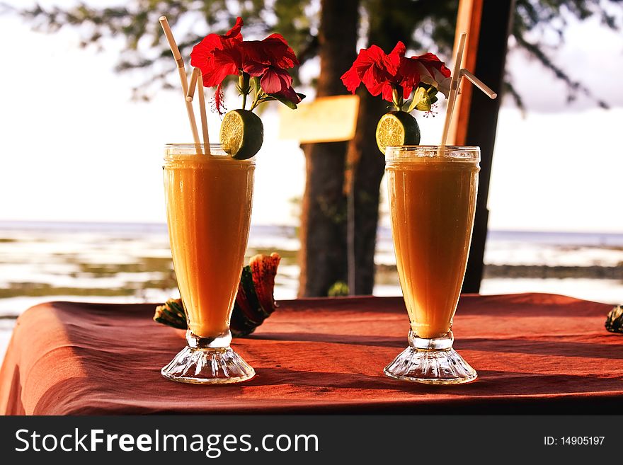 A tropical cocktail on the table, on the beach