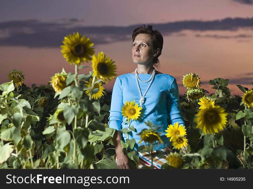 Damsel in sunflower field illuminated with flash