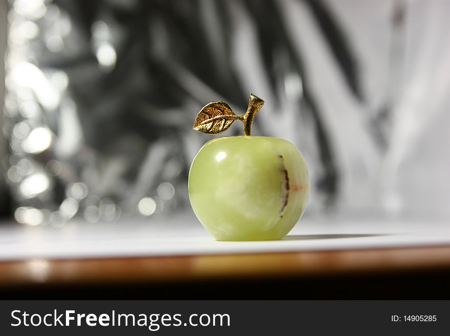 Green artificial apple on the metal background hard light