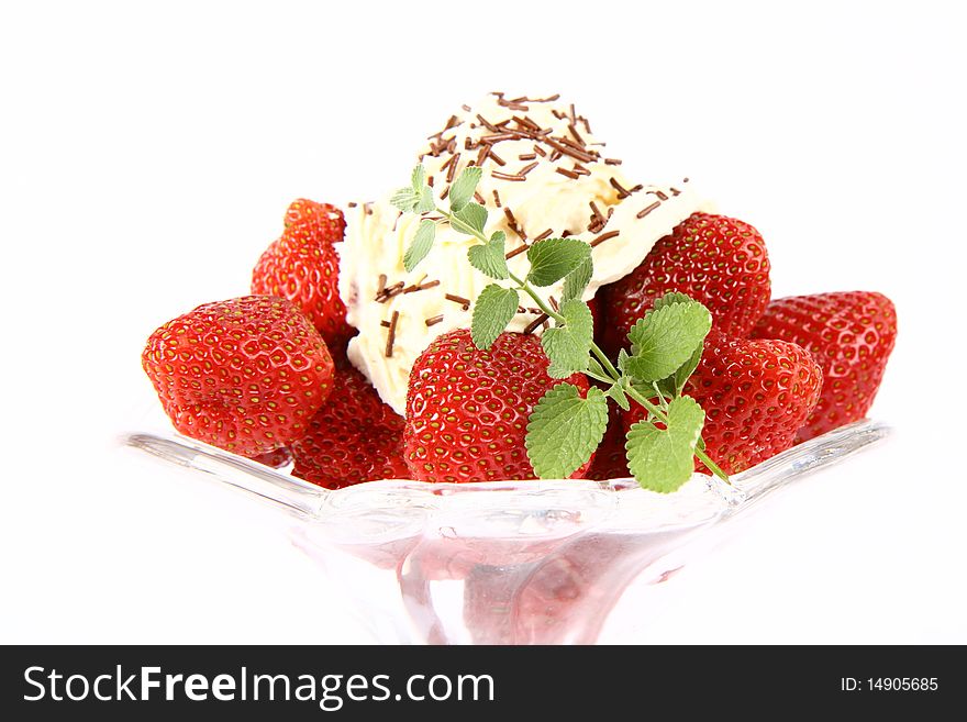 Strawberries in a glass cup with whipped cream, chocolate sprinkles and lemon balm twig. Strawberries in a glass cup with whipped cream, chocolate sprinkles and lemon balm twig