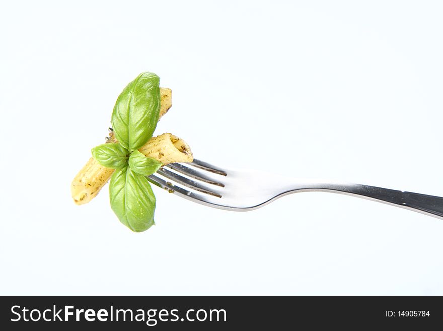 Penne with pesto on a fork