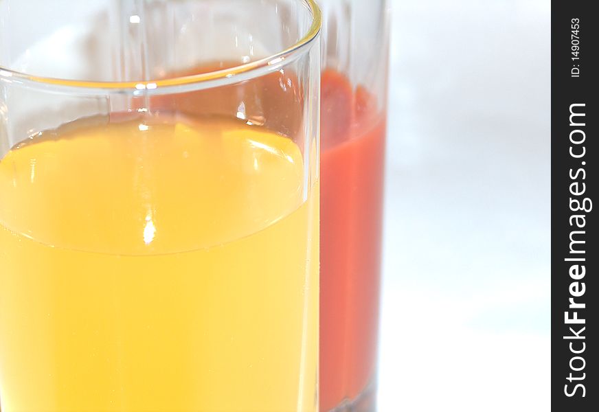 The tomato and orange juice in glass. The tomato and orange juice in glass.