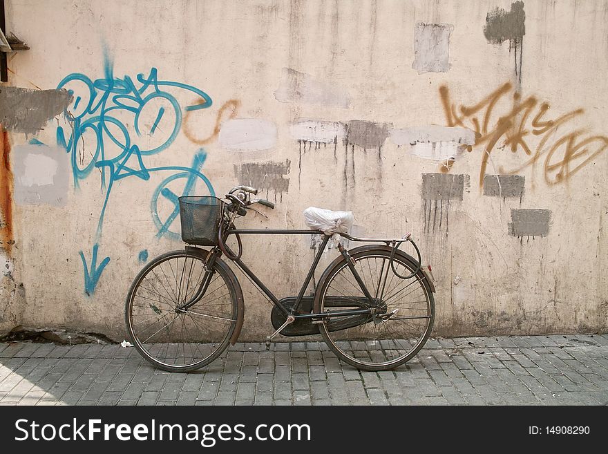 An old bicycle is parking beside a smear wall. An old bicycle is parking beside a smear wall