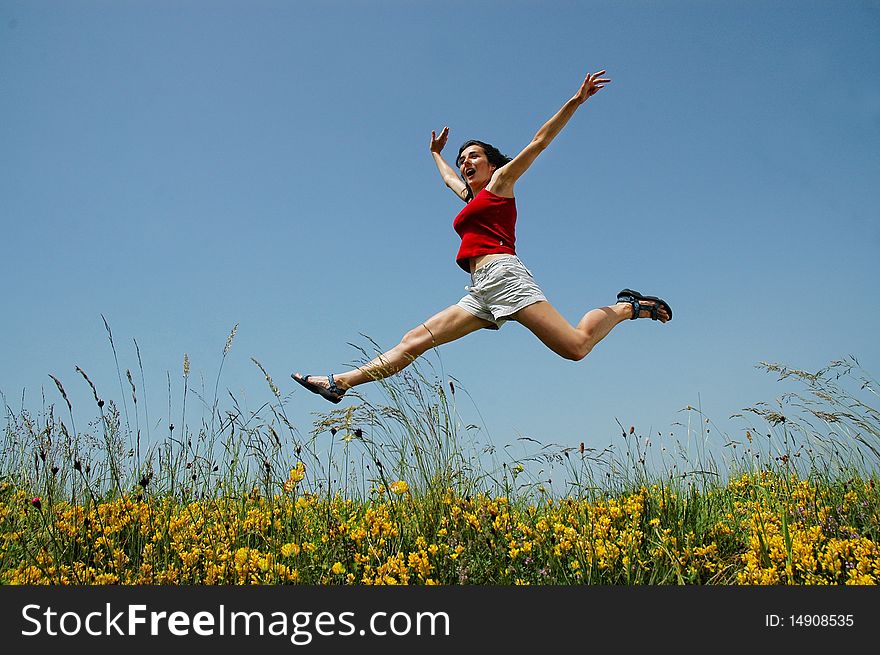 Beautiful young girl jumping in a meadow