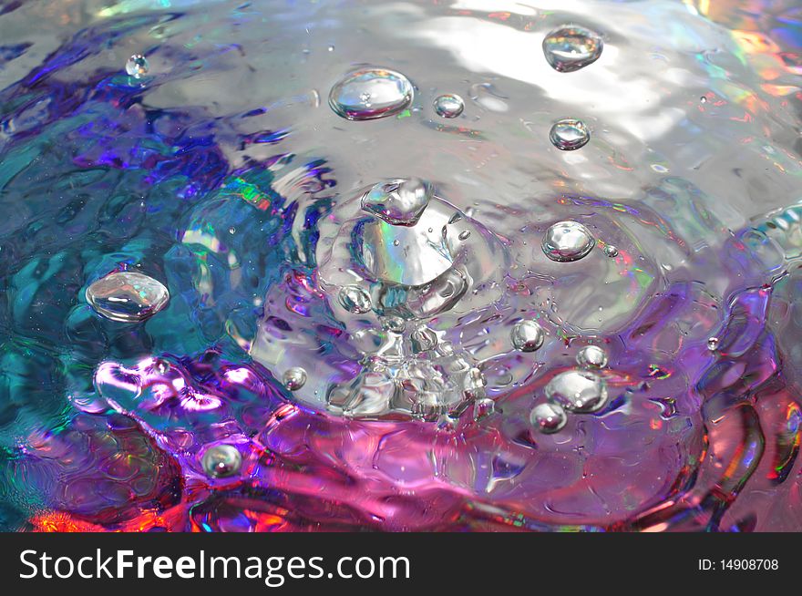 Water bubbles from a faucet with a bold metallic backdrop. Water bubbles from a faucet with a bold metallic backdrop.