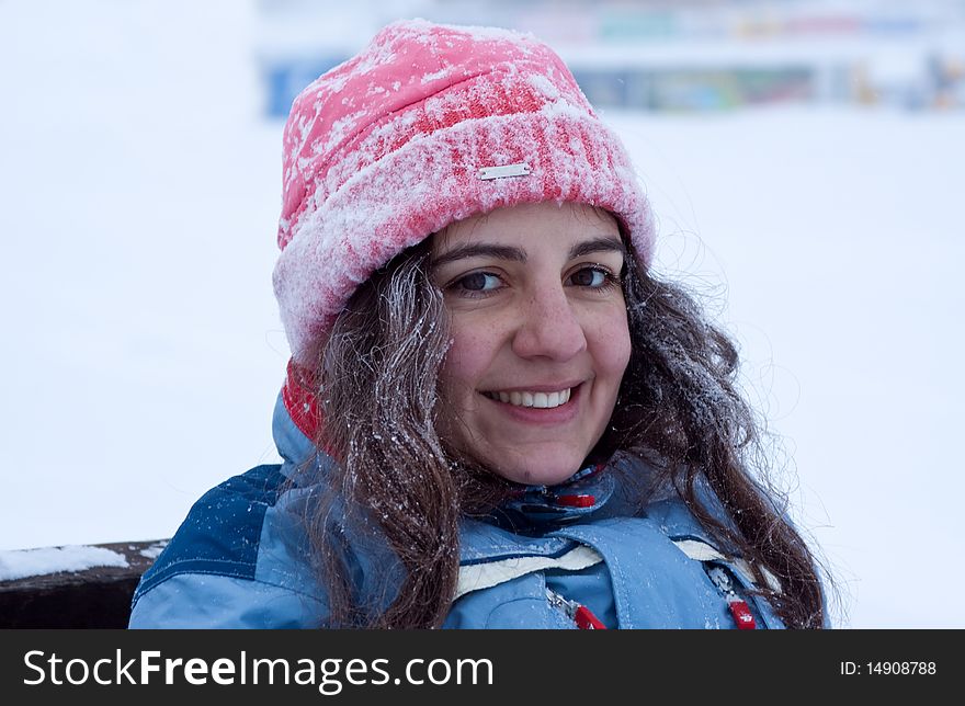 Young woman, resting a little bit after a long skiing, sitting on a bench, smiling. Young woman, resting a little bit after a long skiing, sitting on a bench, smiling