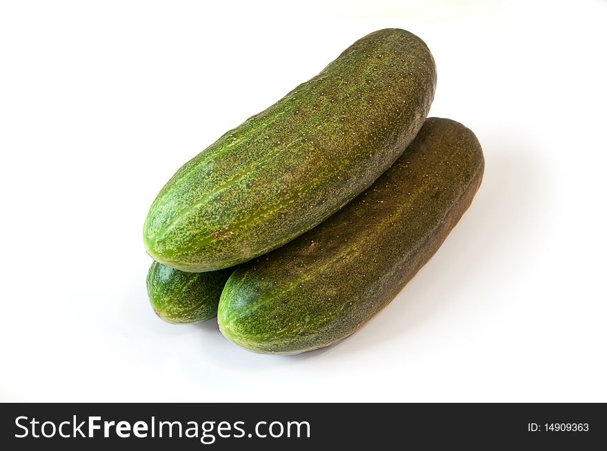Three ripe cucumbers with a shade on a white background