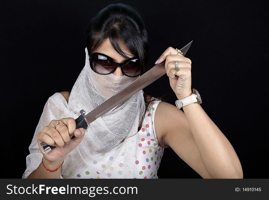 Girl posing with sharp sword in studio. Girl posing with sharp sword in studio.