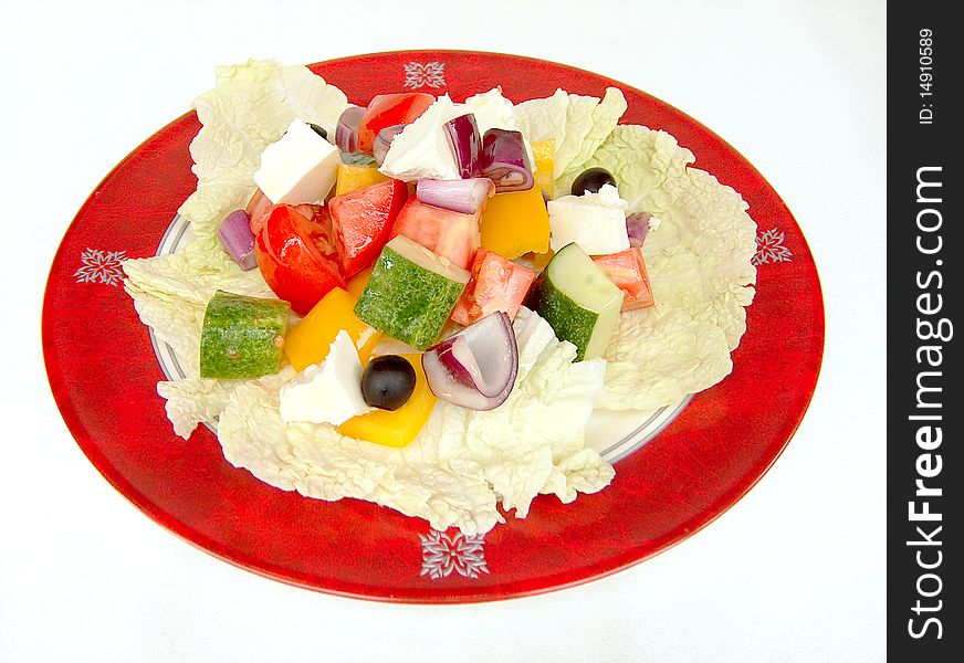 Peppers, onions, cheese, tomatoes and olive are coarsely cut and placed on large lettuce leaves. This salad is placed on a round white plate with a red border. Peppers, onions, cheese, tomatoes and olive are coarsely cut and placed on large lettuce leaves. This salad is placed on a round white plate with a red border.