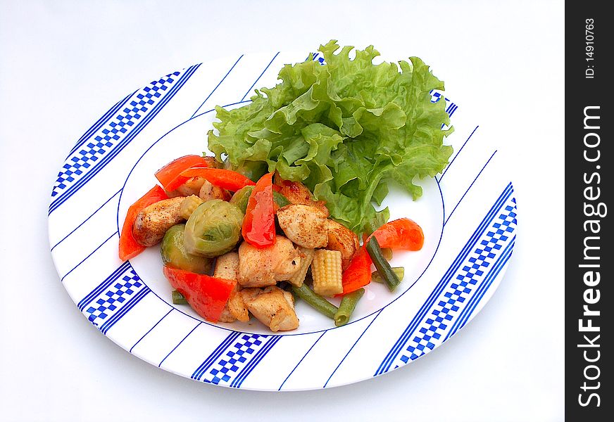The plate with blue ornament. The pieces of chicken with Brussels sprout, a paprika, corn, an asparagus and lettuce leaves. The plate with blue ornament. The pieces of chicken with Brussels sprout, a paprika, corn, an asparagus and lettuce leaves.