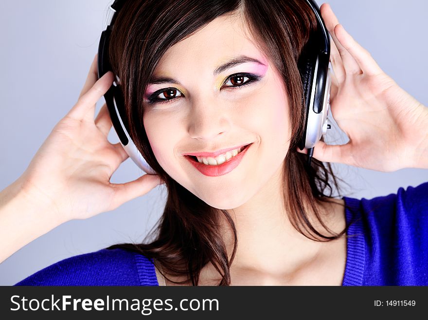 Shot of a pretty young woman in headphones listening to music with pleasure. Shot in a studio. Shot of a pretty young woman in headphones listening to music with pleasure. Shot in a studio.