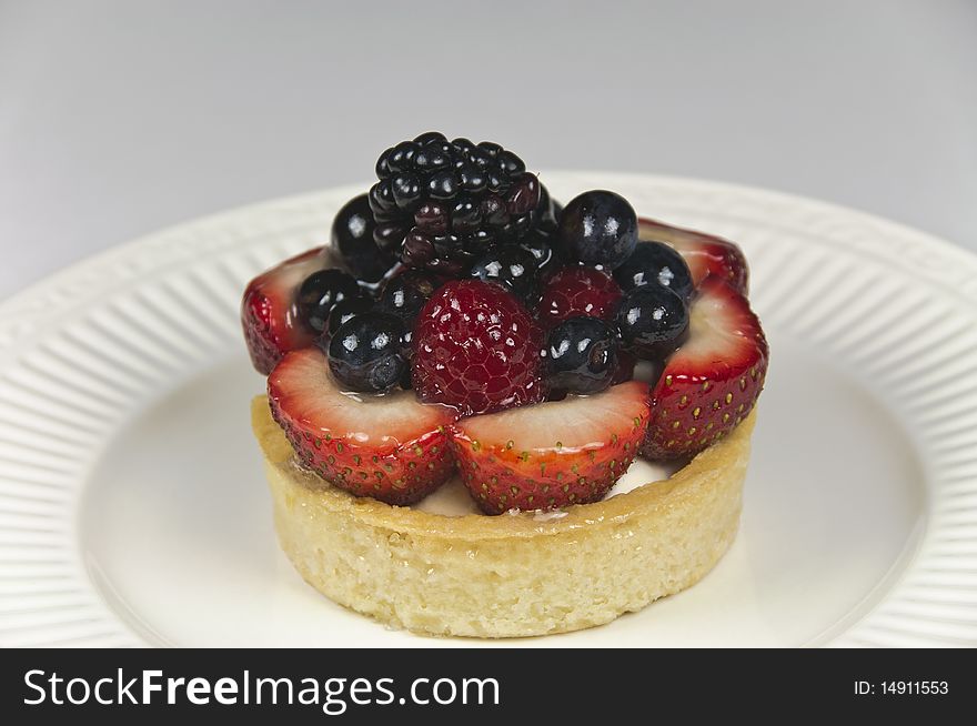 Delicious mixed berry patisserie tart. Red, white and blue holiday celebration theme. Soft focus, close-up. Delicious mixed berry patisserie tart. Red, white and blue holiday celebration theme. Soft focus, close-up.