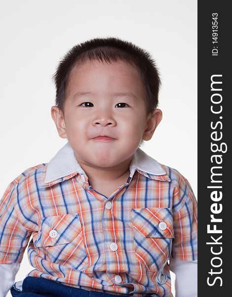 2 year old Asian boy in plaid shirt on white background