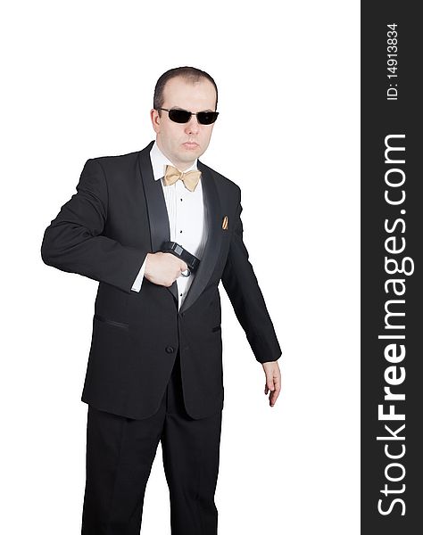 Man in tuxedo with sunglasses, taking out or hiding gun. Man in tuxedo with sunglasses, taking out or hiding gun.