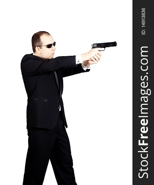 Man in tuxedo with glasses aiming with a gun to the left. Man in tuxedo with glasses aiming with a gun to the left