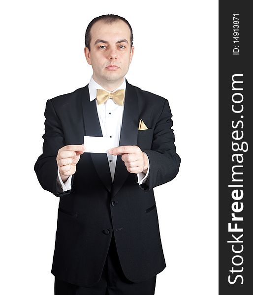 Man in tuxedo holding blank buisness card with both hands.