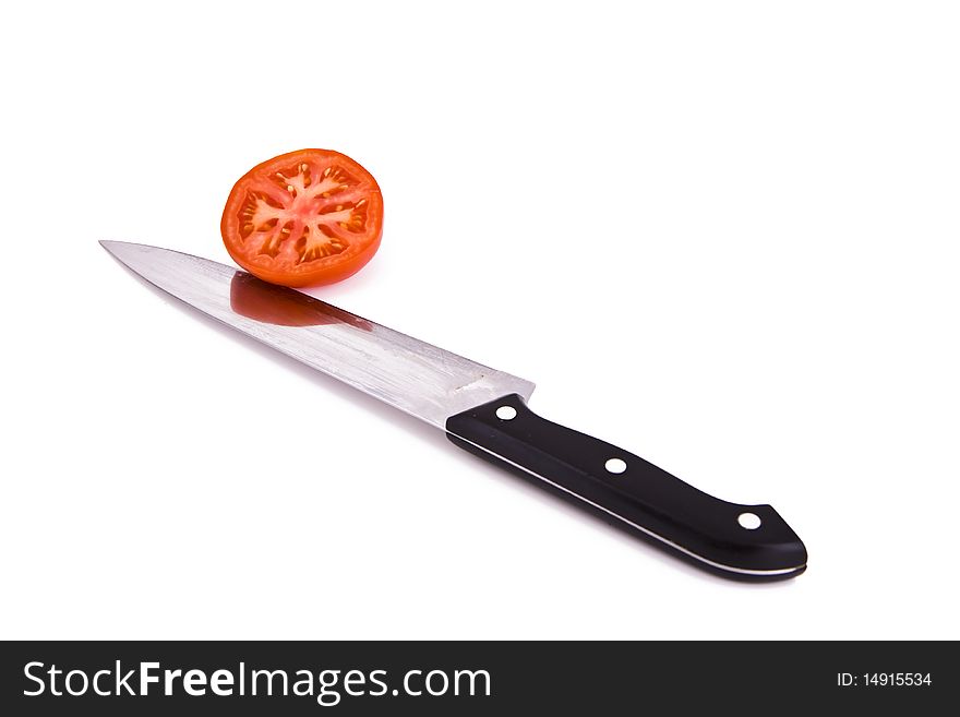 Fresh tomato cut with a kitchen knife isolated on white. Fresh tomato cut with a kitchen knife isolated on white