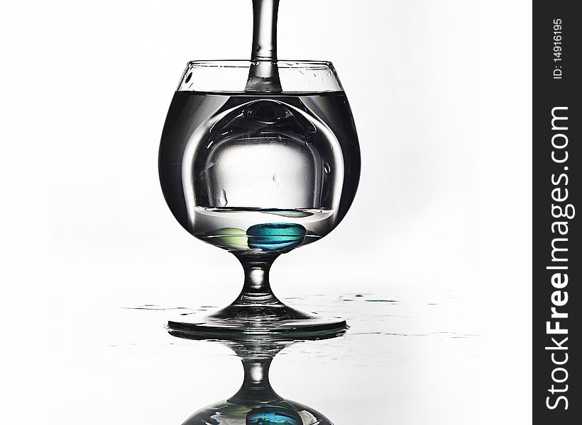 Glass in glass with water and pills