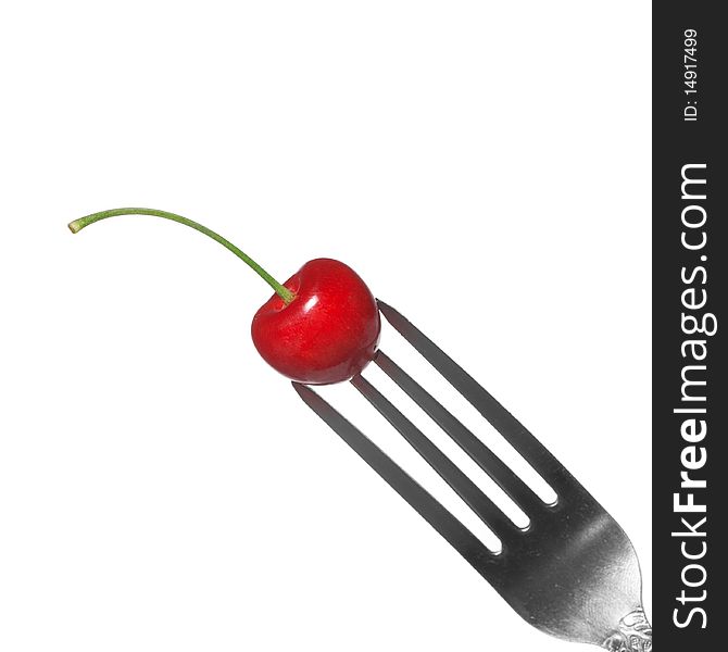 Red cherry on fork isolated on white