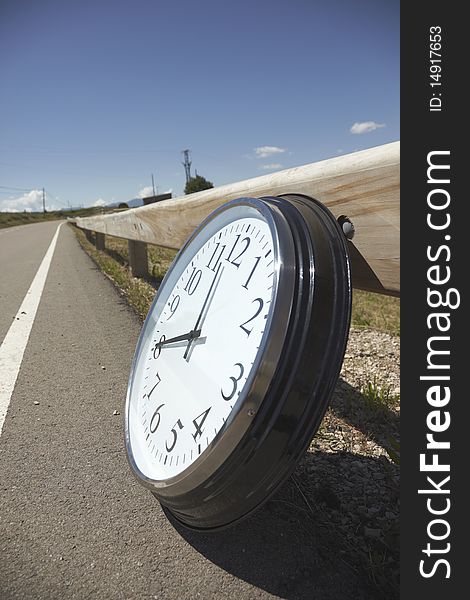 Big white clock on the road on a sunny day. Outdoors pictures with natural light taken with a Canon EOS 5D Mark II and the Canon 24-105mm. Big white clock on the road on a sunny day. Outdoors pictures with natural light taken with a Canon EOS 5D Mark II and the Canon 24-105mm.