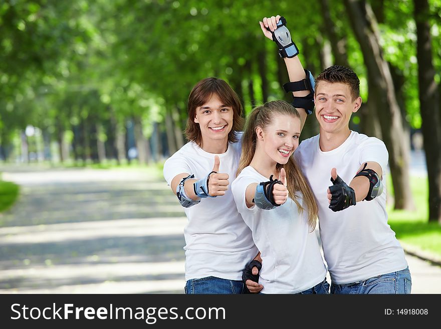 Three young people in equipment show a thumb upwards. Three young people in equipment show a thumb upwards