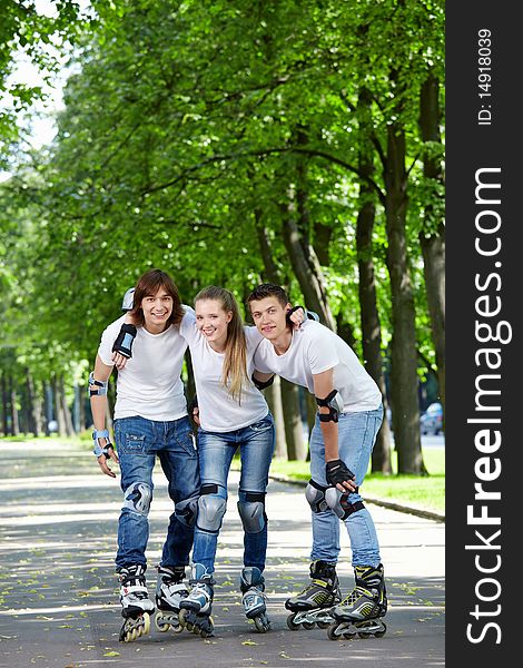 Three young people on rollers in park