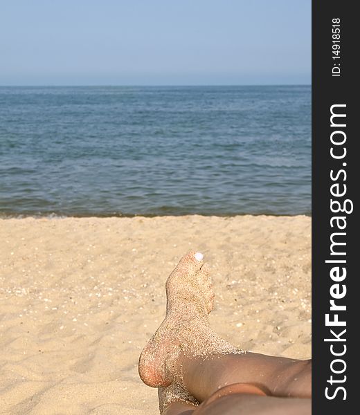 Two women feet on the calm and sunny, empty beach. Two women feet on the calm and sunny, empty beach.