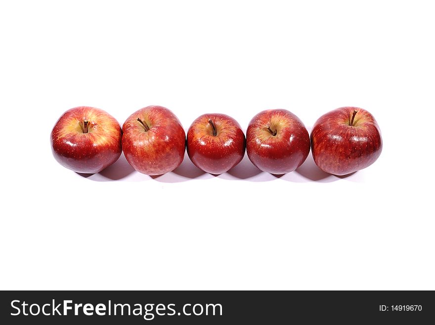 Apples in a row on white with natural shadow.