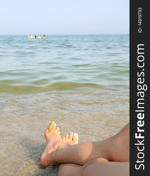 Two women feet on the calm and sunny, empty beach. Two women feet on the calm and sunny, empty beach.